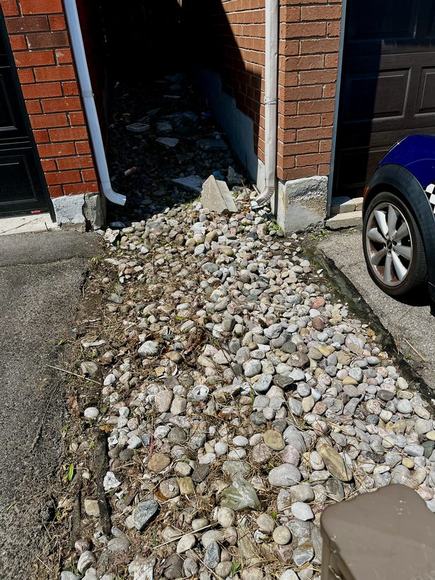Cleared and stone-lined garden bed after landscaping